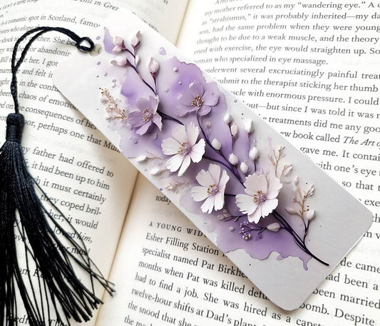 A pretty bookmark gift. white and modern with purple and soft white flowers /elements. Stunning bookmark making the perfect gift. comes with a tassel.