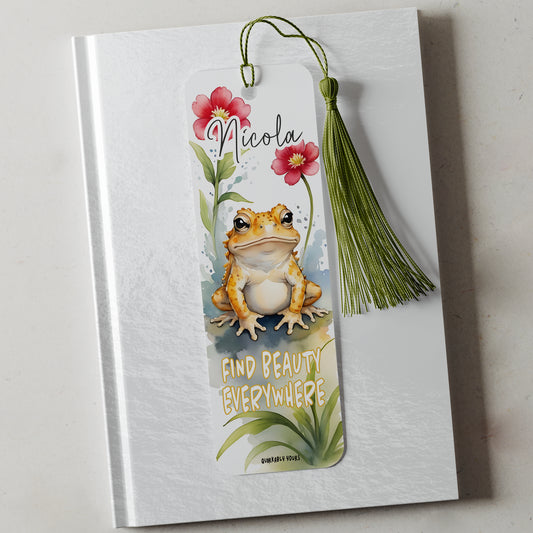 Bookmark with frog illustration and floral design on a white notebook