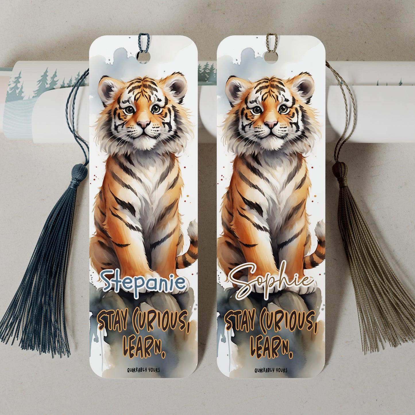 Two tiger-themed bookmarks with tassels on a neutral background