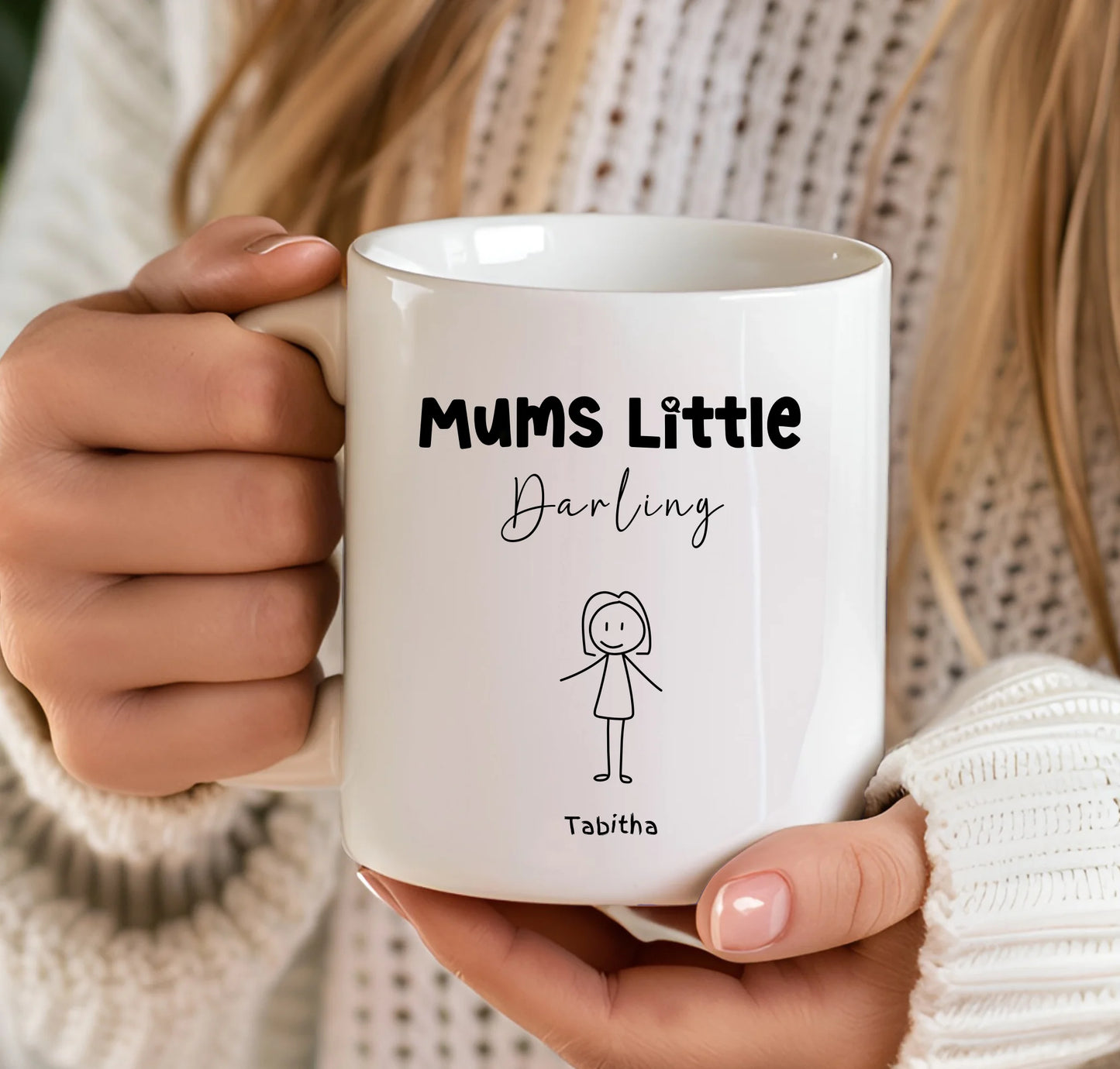 Person holding a white mug with 'Mums Little Darling' text and a small illustration.