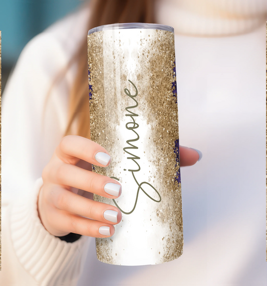 Hand holding a glittery tumbler with 'simone' printed on it against a white and gold glitter background