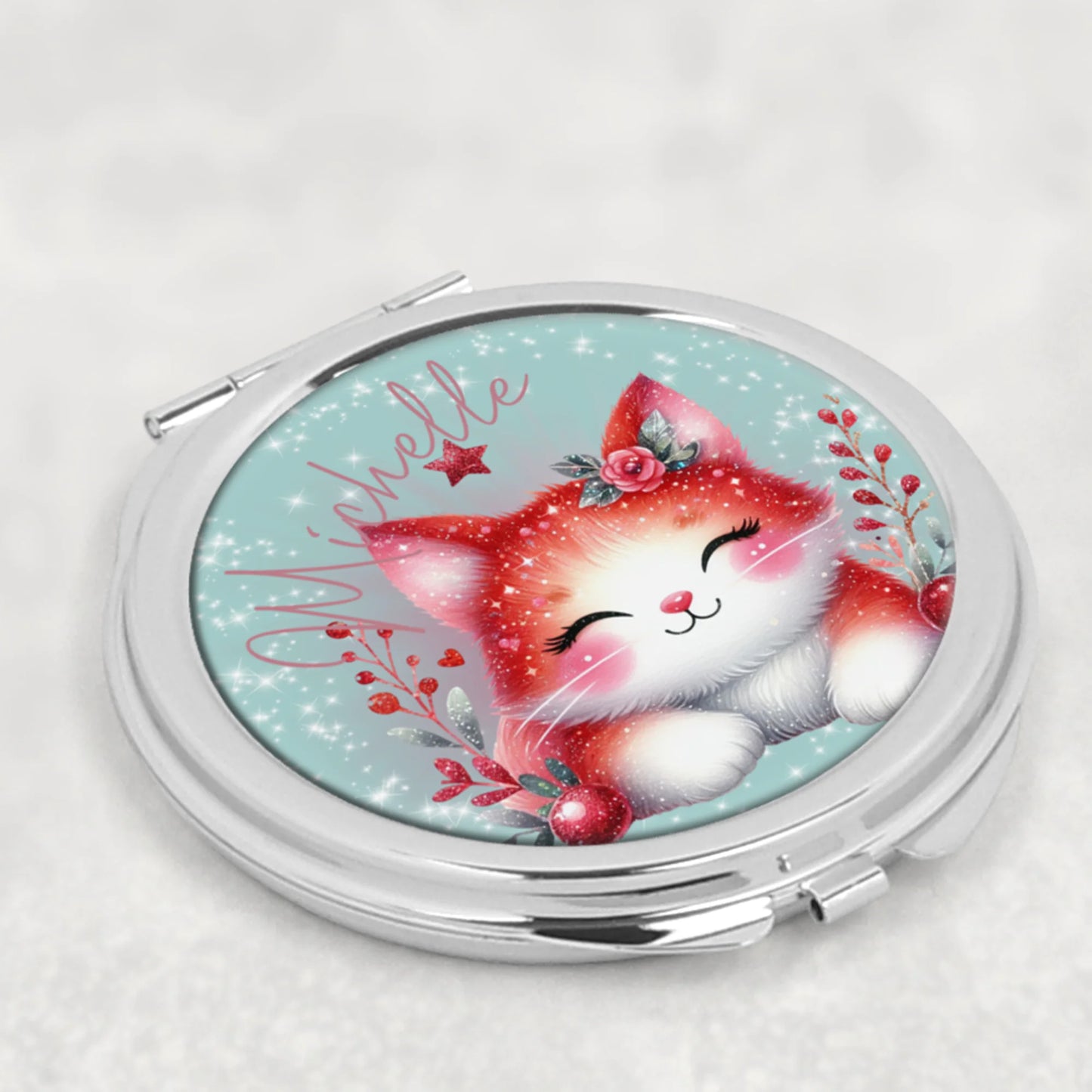 Compact mirror with a red and white cat illustration on a light blue background