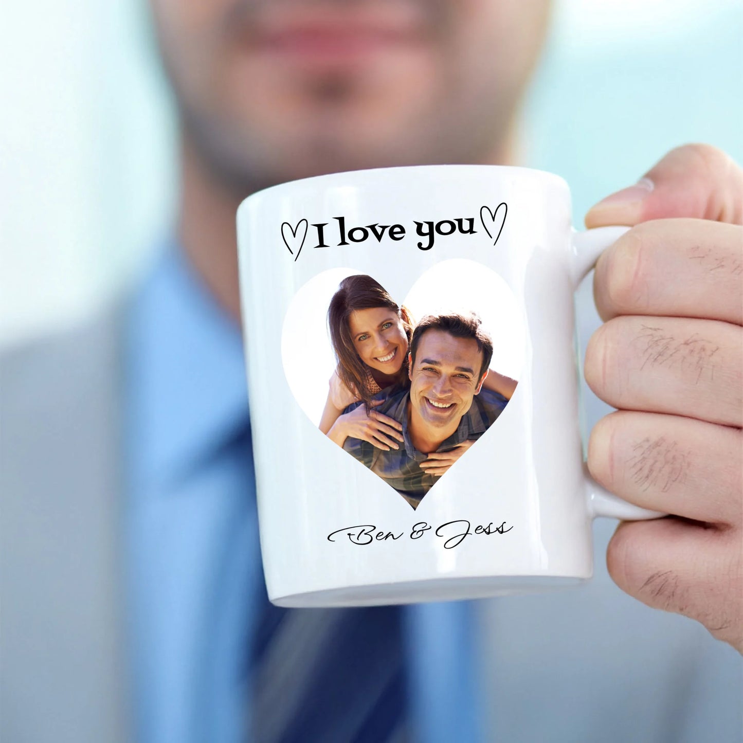 Person holding a white mug with a personalised photo and 'I love you' text.