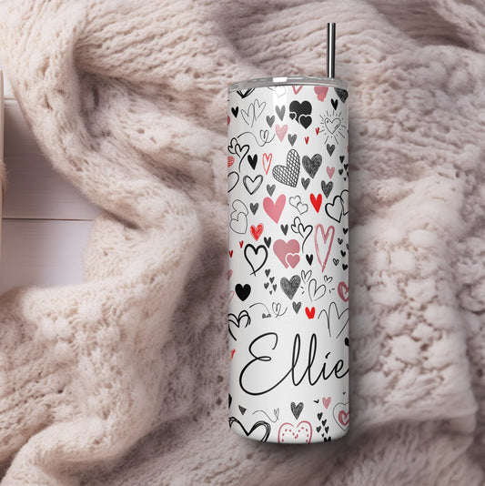 Tumbler with heart pattern and 'Ellie' text on a soft fabric background