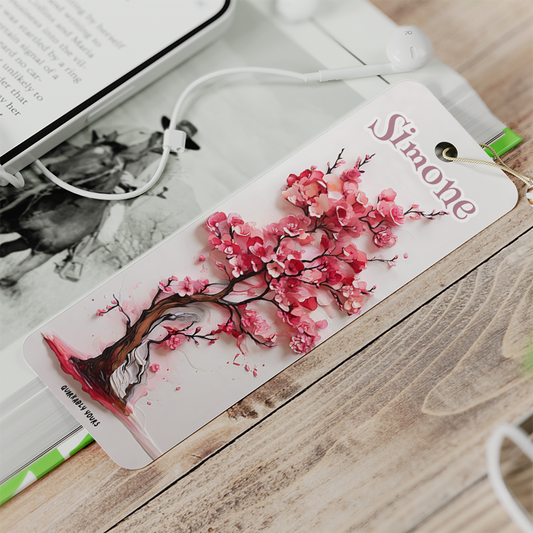 Bookmark with cherry blossom design and 'Simone' text on a wooden surface