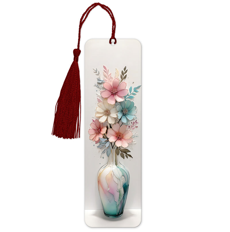 A bookmark featuring a 3D floral design with pink and blue flowers in a vase, set against a white background with a red tassel.