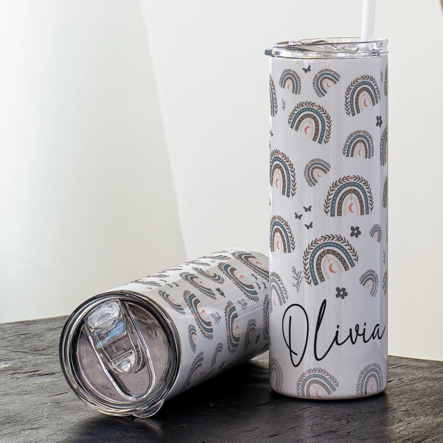 Tumbler with rainbow pattern and 'Olivia' text on a wooden surface