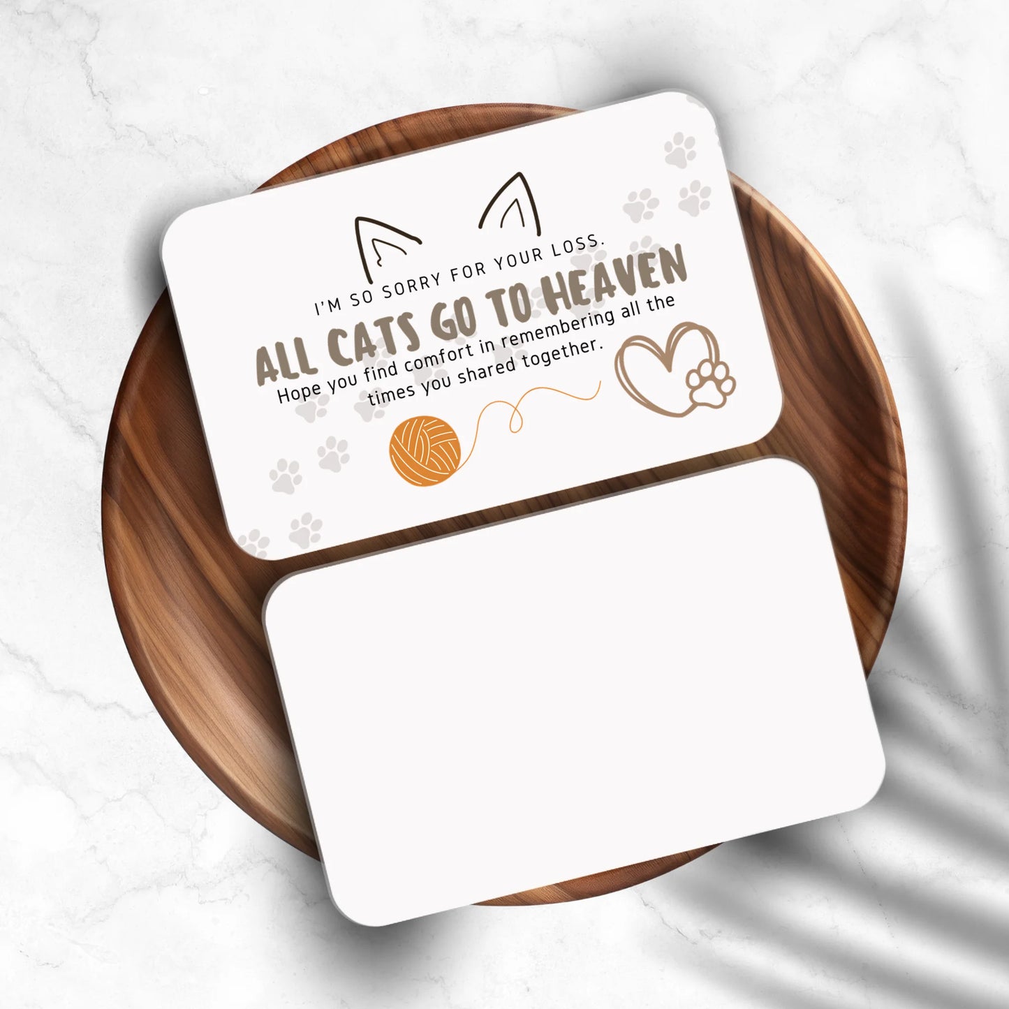 Card with sympathy message for cat loss on a wooden coaster