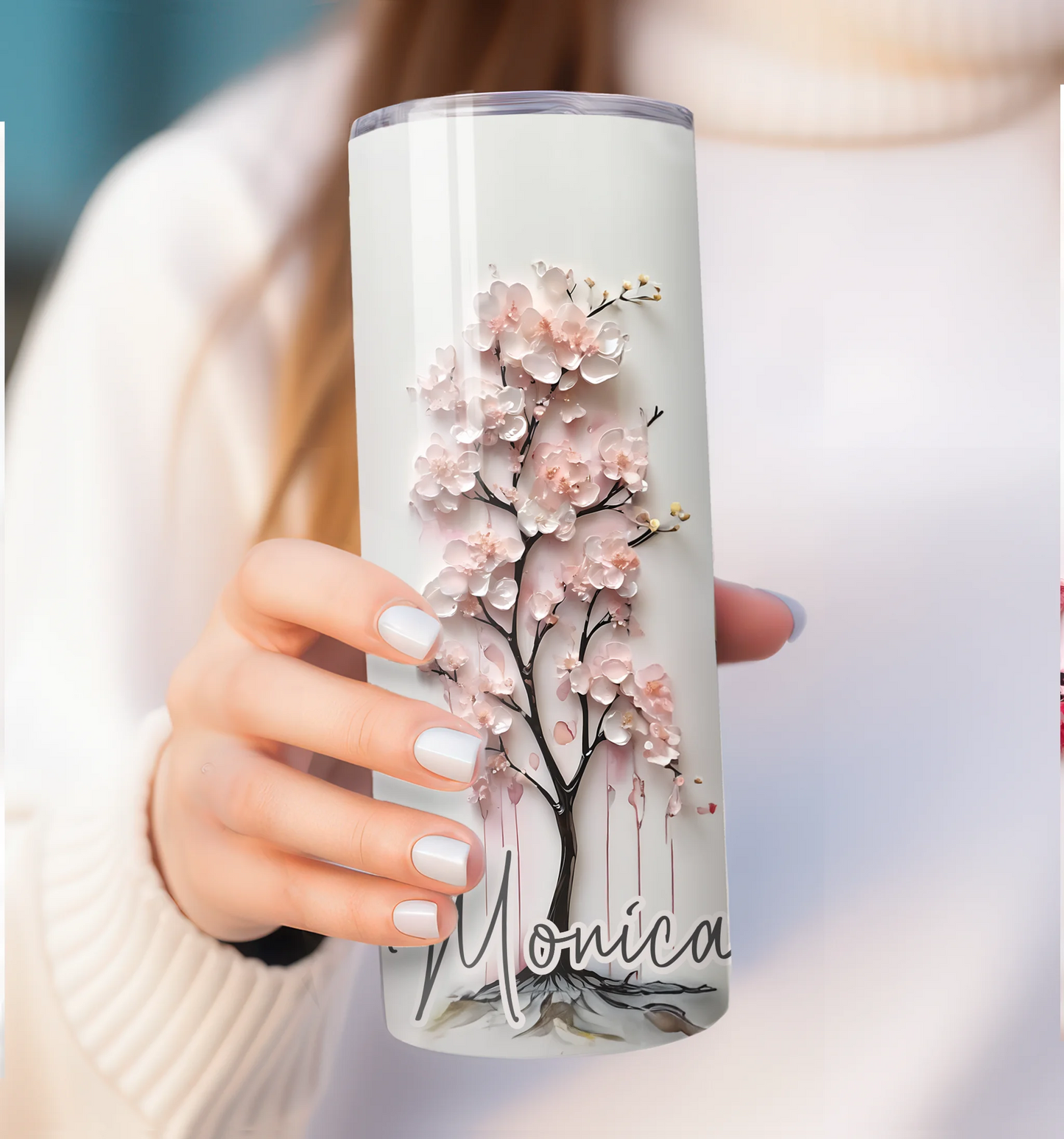 Tumbler with cherry blossom design and name 'Monica' held by a person.