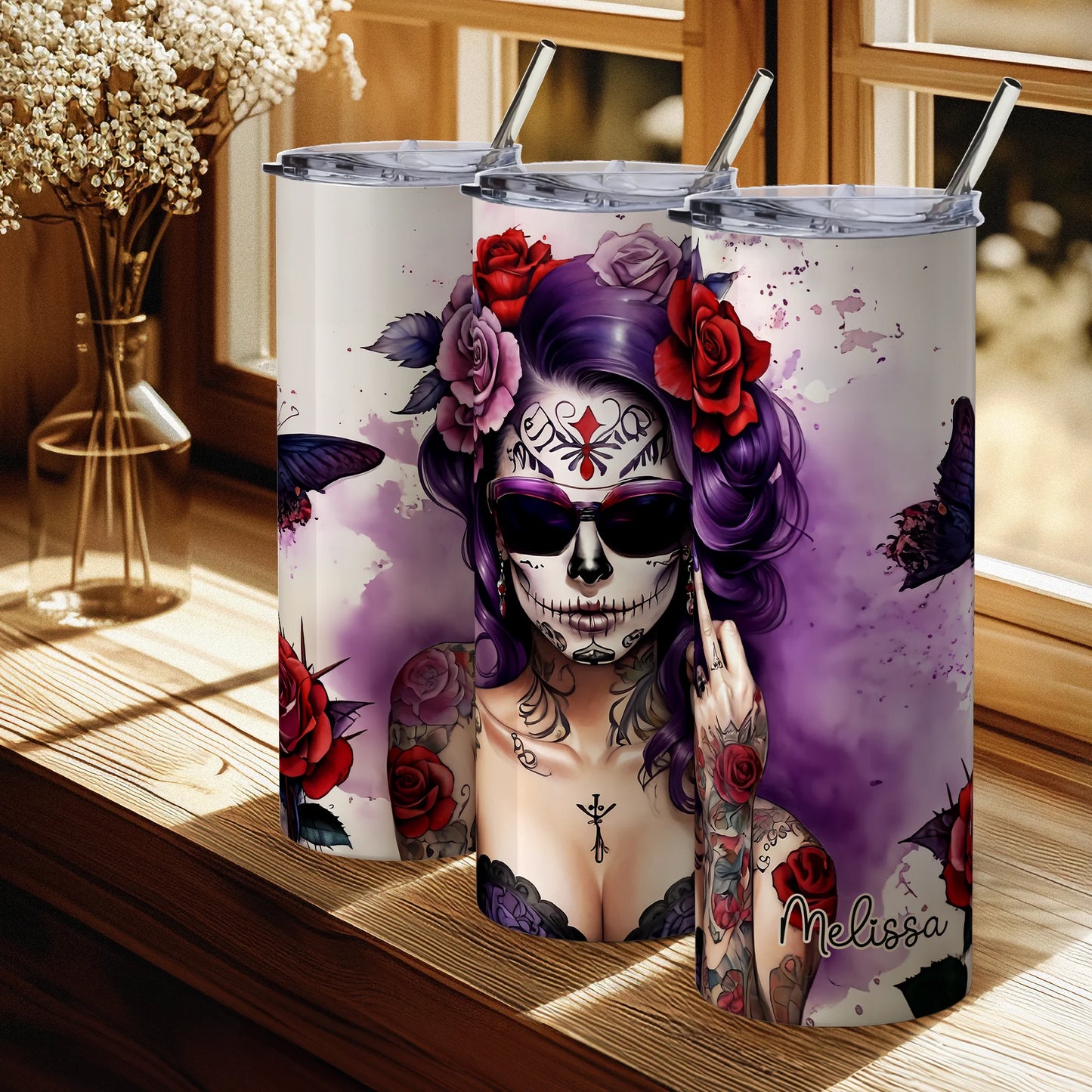 Tumbler with a colorful design of a woman with a skull makeup and tattoos, placed on a wooden surface.