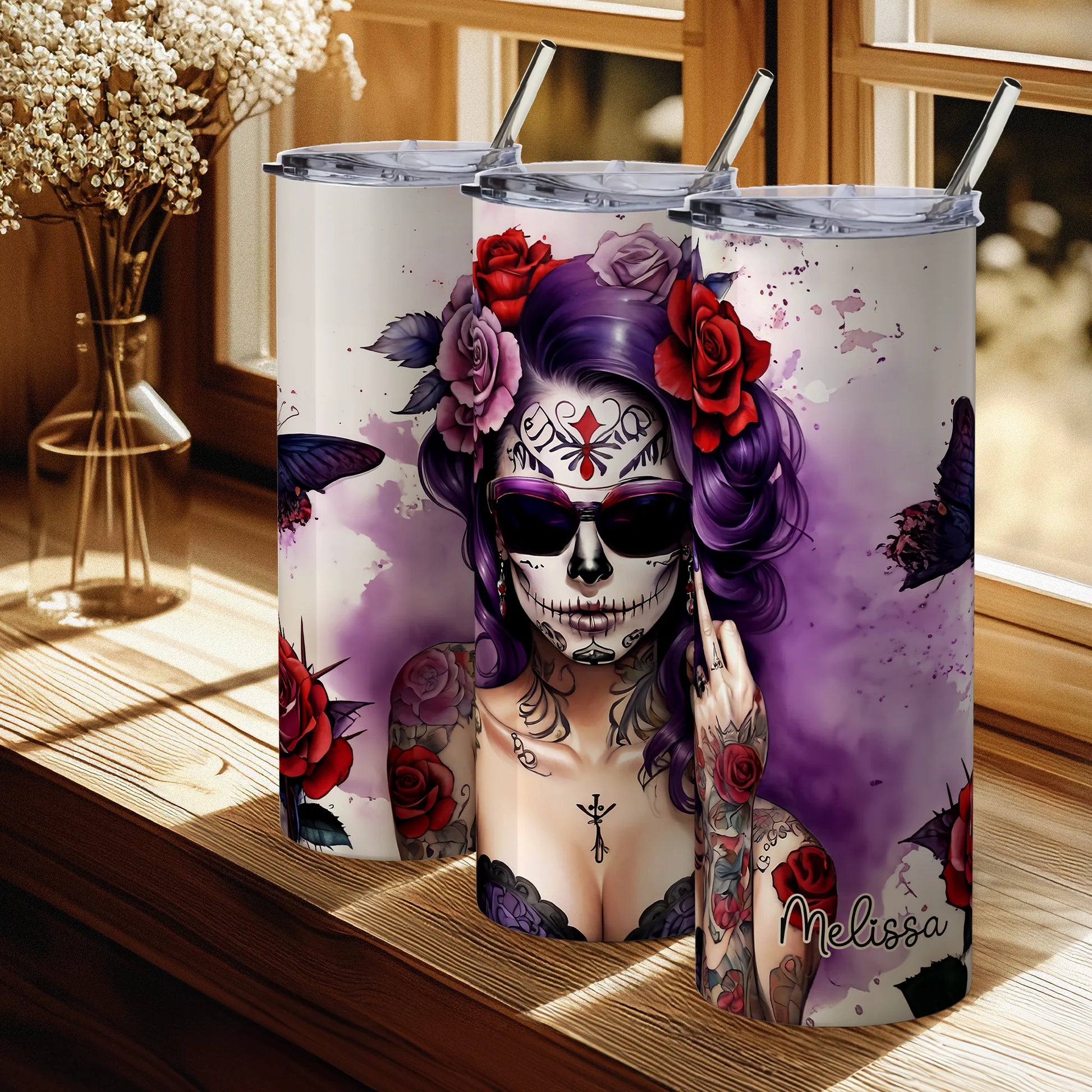 Tumbler with a colorful design of a woman with a skull makeup and tattoos, placed on a wooden surface.