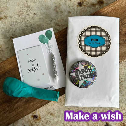 Badge, balloon, pud in a mug for the make a wish birthday box in blue