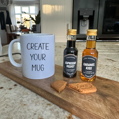 White mug with 'Create Your Mug' text, two syrup bottles, and cookies on a wooden board.