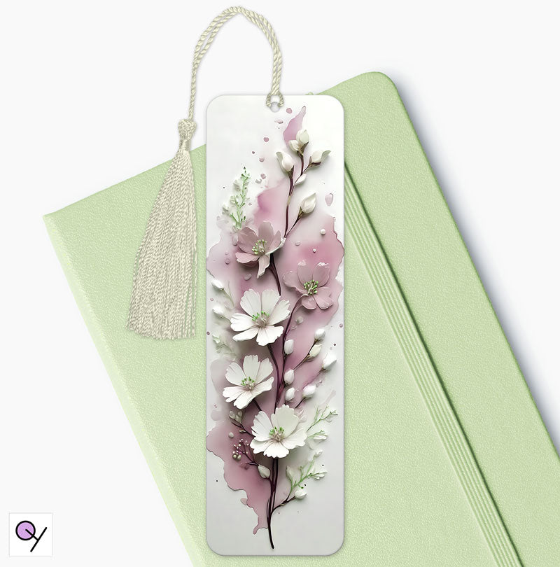 Elegant 3D Flower Bookmark: Beautiful aluminium bookmark with 3D pink and white flowers on a sleek white background. Size: 15cm x 4.5cm. Ideal as a gift. The boomark is laying on a mint green diary and has a cream tassel.