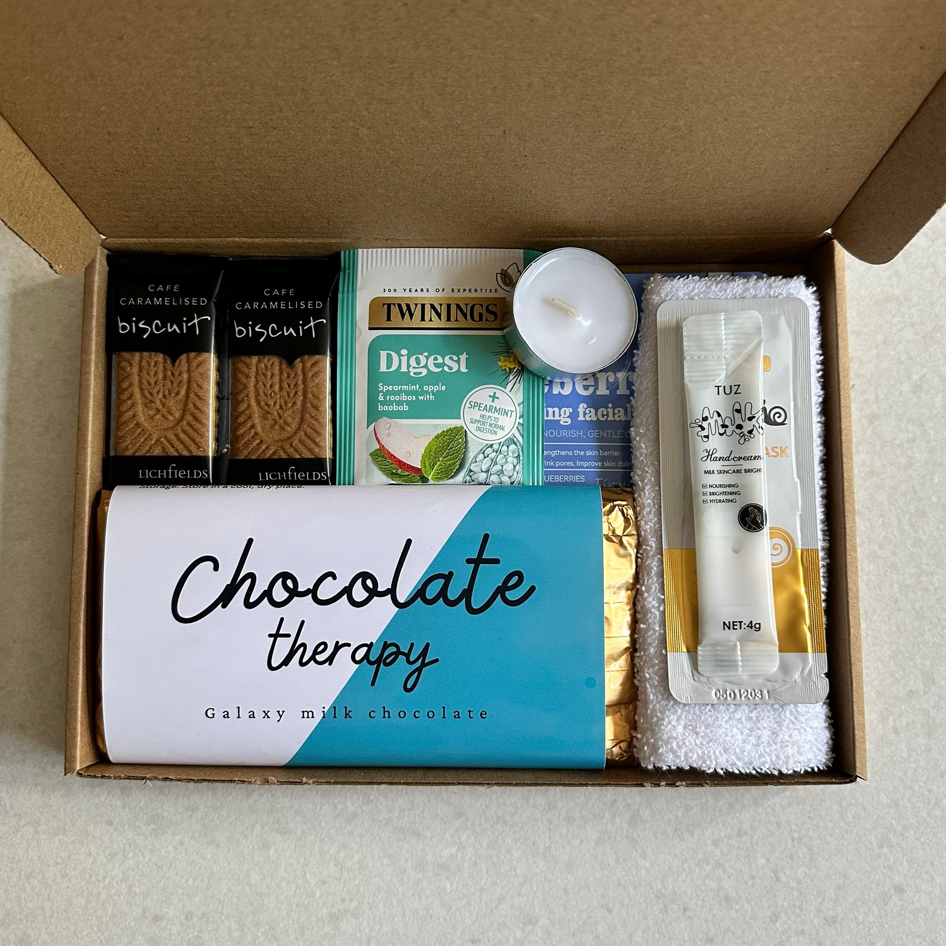 Thinking of you gift box containing a variety of items including chocolate, tea, and skincare products.