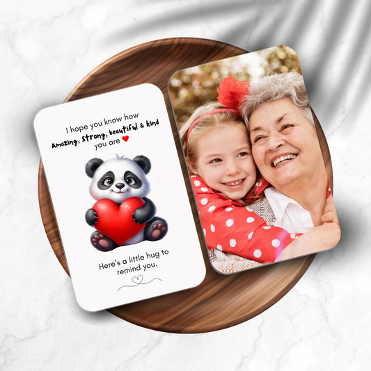 Card with panda holding a heart and message, next to a photo of a girl and woman hugging on a wooden plate.