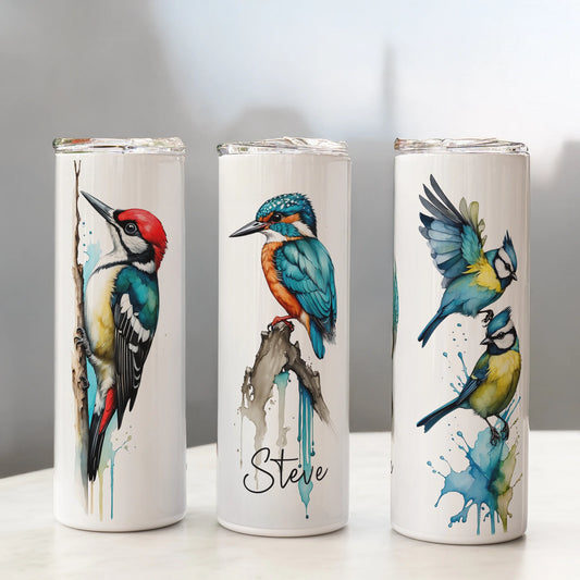 Three white tumblers with bird illustrations on a gray background