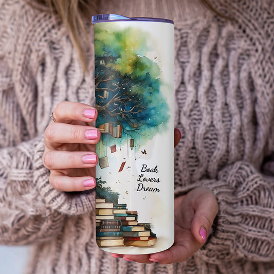Person holding a tumbler with a 'Book Lovers Dream' design featuring books and a tree.
