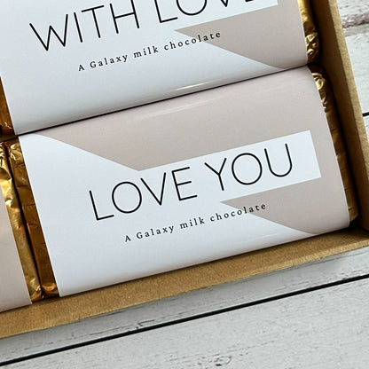 mum-chocolate-surprise - Chocolate bars with messages like 'Love You' and MUM in a box on a wooden surface