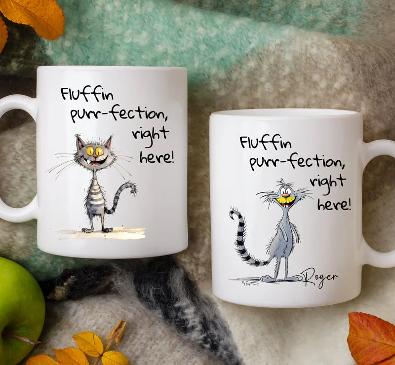 Two white mugs with a cartoon cat and humorous text on a textured surface with autumn leaves.