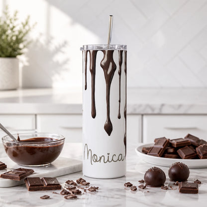 A tall white insulated tumbler with a clear lid and metal straw, decorated with dark brown chocolate drip graphics and personalised with a name