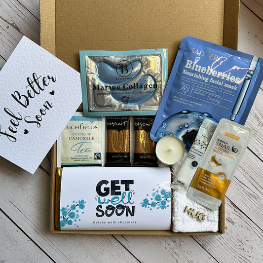 Get well soon care package with various items including tea, a candle, and skincare products on a wooden surface.