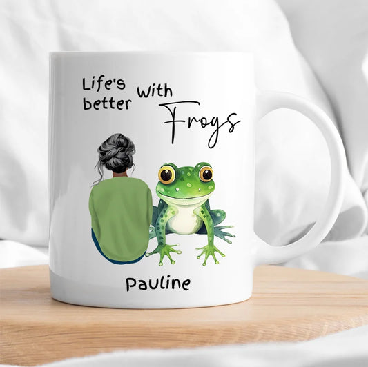 Mug with a design of a person and a frog, with text 'Life's better with frogs Pauline' on a white background.
