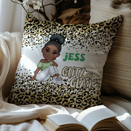 Decorative pillow with a leopard print pattern and a person wearing a green top and white pants, with text 'JESS GLITZ AND GLAM' on a couch.