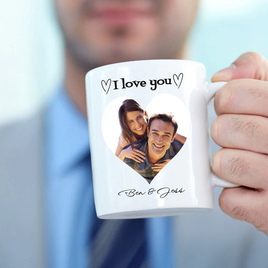 Person holding a white mug with a personalised photo and 'I love you' text.