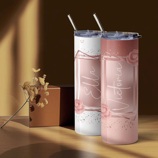 Two pink tumblers with floral designs and 'Victoria' text on a wooden surface.