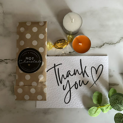 Hot chocolate package, candles, and 'thank you' card orange and brown thank you gift packaging