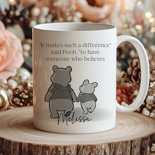 Mug with Winnie the Pooh design and text on a wooden surface with decorative background