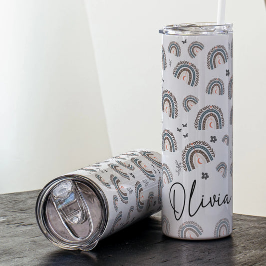 Tumbler with rainbow pattern and 'Olivia' text on a wooden surface