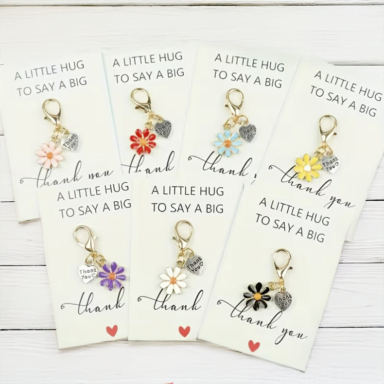 Thank You gift box contents including hand cream, mask and candle and Keychains with floral designs on cards that say 'A little hug to say a big thank you